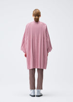 A model wears the PLEATS PLEASE ISSEY MIYAKE SMOOTH COAT coat.