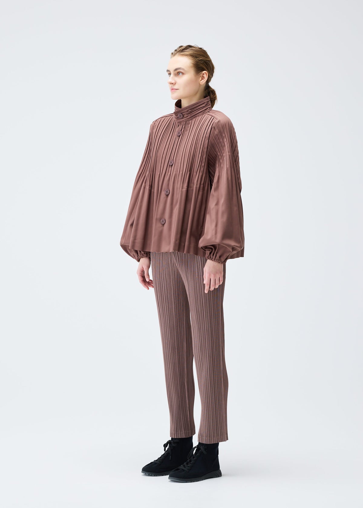 A model wears the PLEATS PLEASE ISSEY MIYAKE SMOOTH COAT jacket.