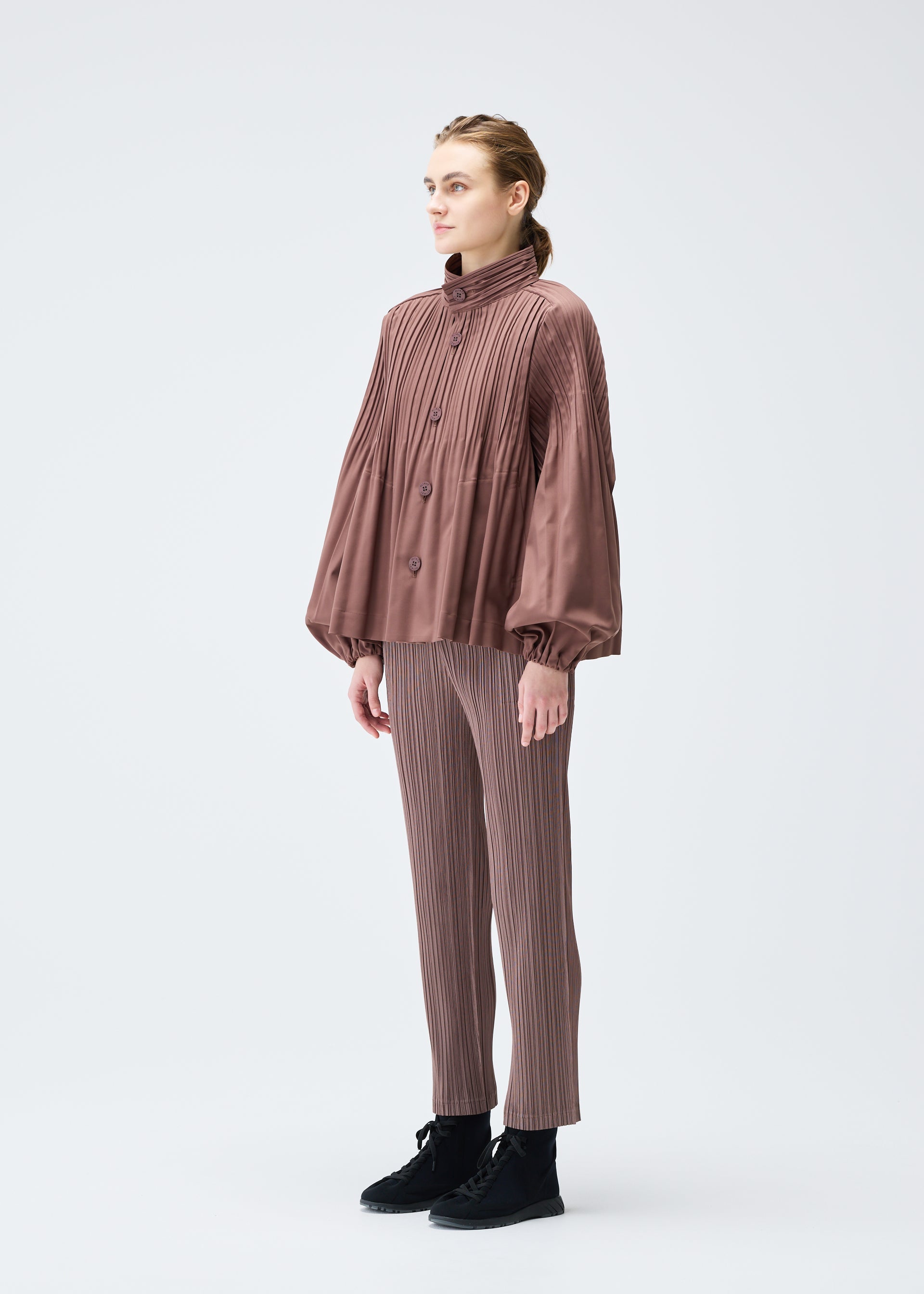 A model wears the PLEATS PLEASE ISSEY MIYAKE SMOOTH COAT jacket.
