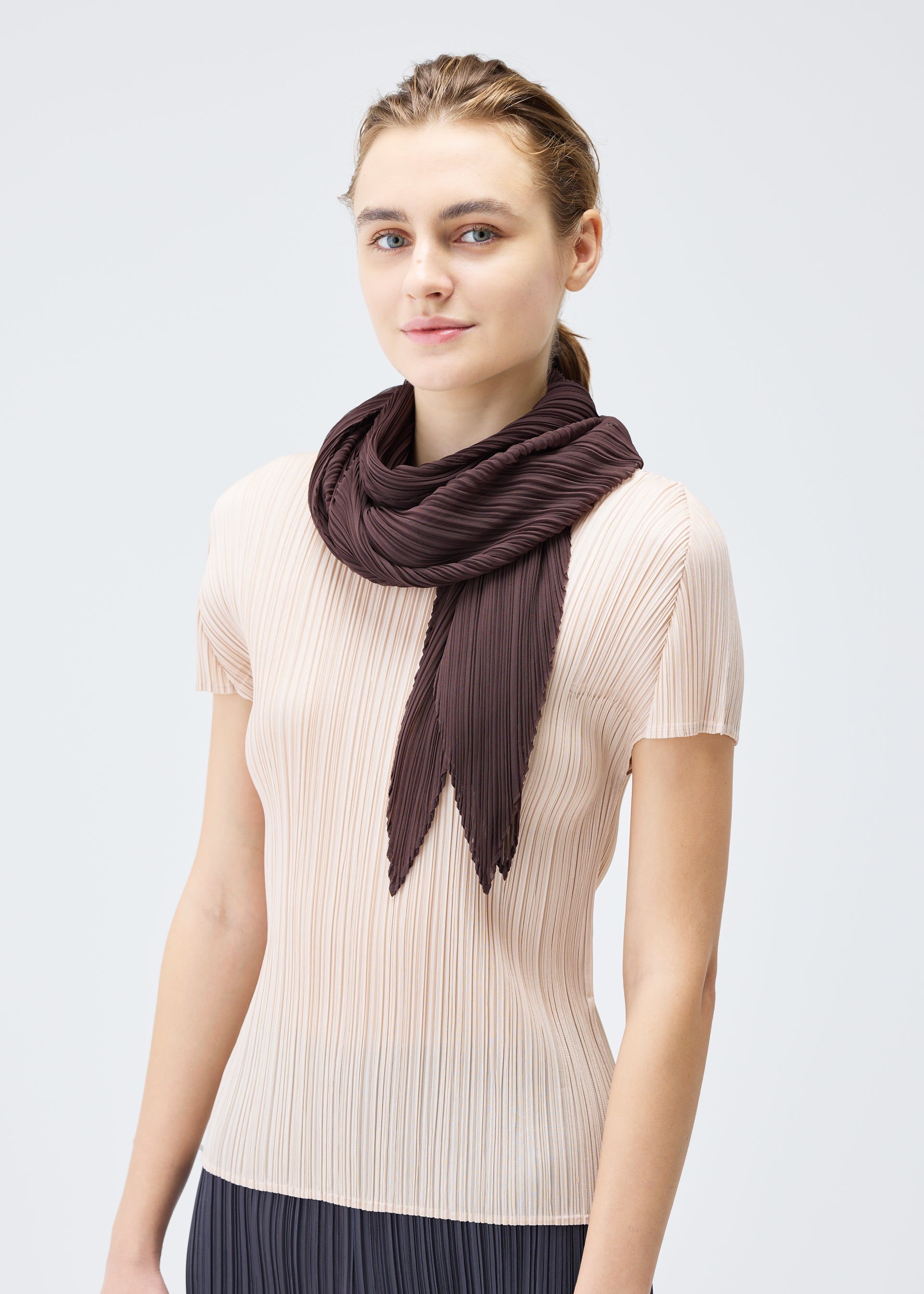 A model wears the PLEATS PLEASE ISSEY MIYAKE MONTHLY SCARF JULY stole.