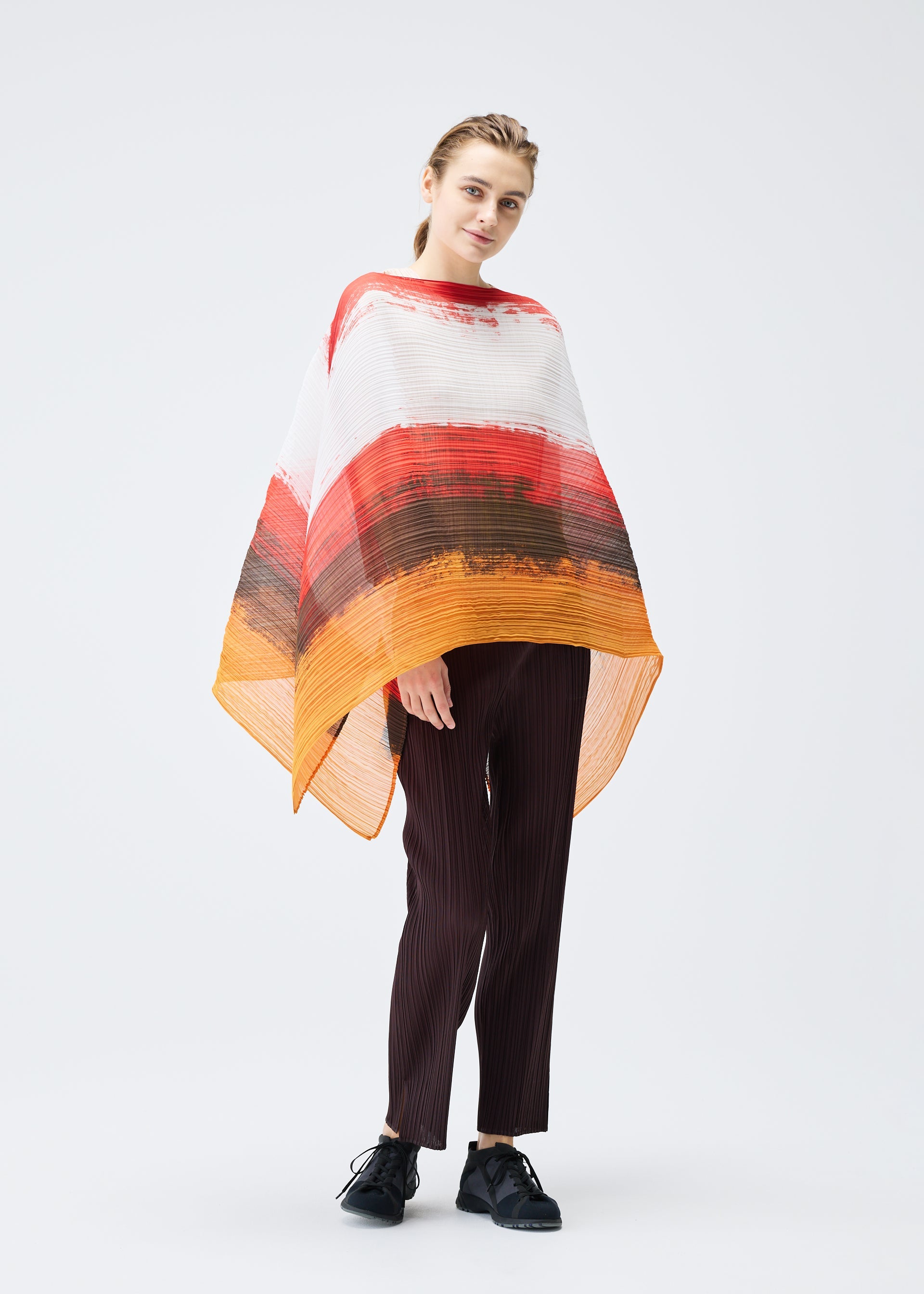 A model wears the PLEATS PLEASE ISSEY MIYAKE JUMP MADAME T stole.