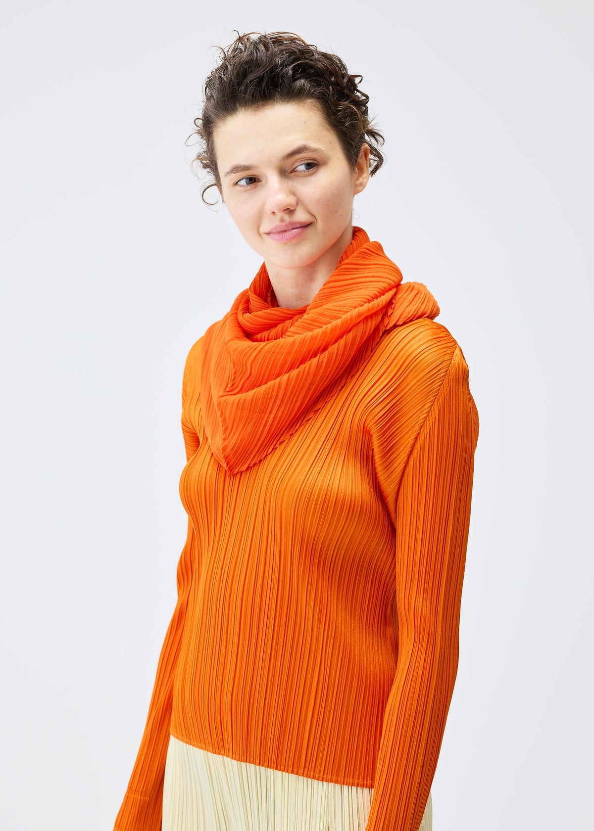 A model wears the PLEATS PLEASE ISSEY MIYAKE O SCARF DECEMBER accessories.