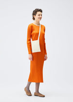A model wears the PLEATS PLEASE ISSEY MIYAKE CREPE KNIT BAG bags.