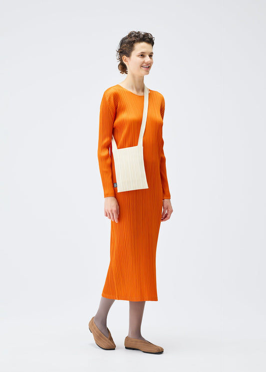 A model wears the PLEATS PLEASE ISSEY MIYAKE CREPE KNIT BAG bags.
