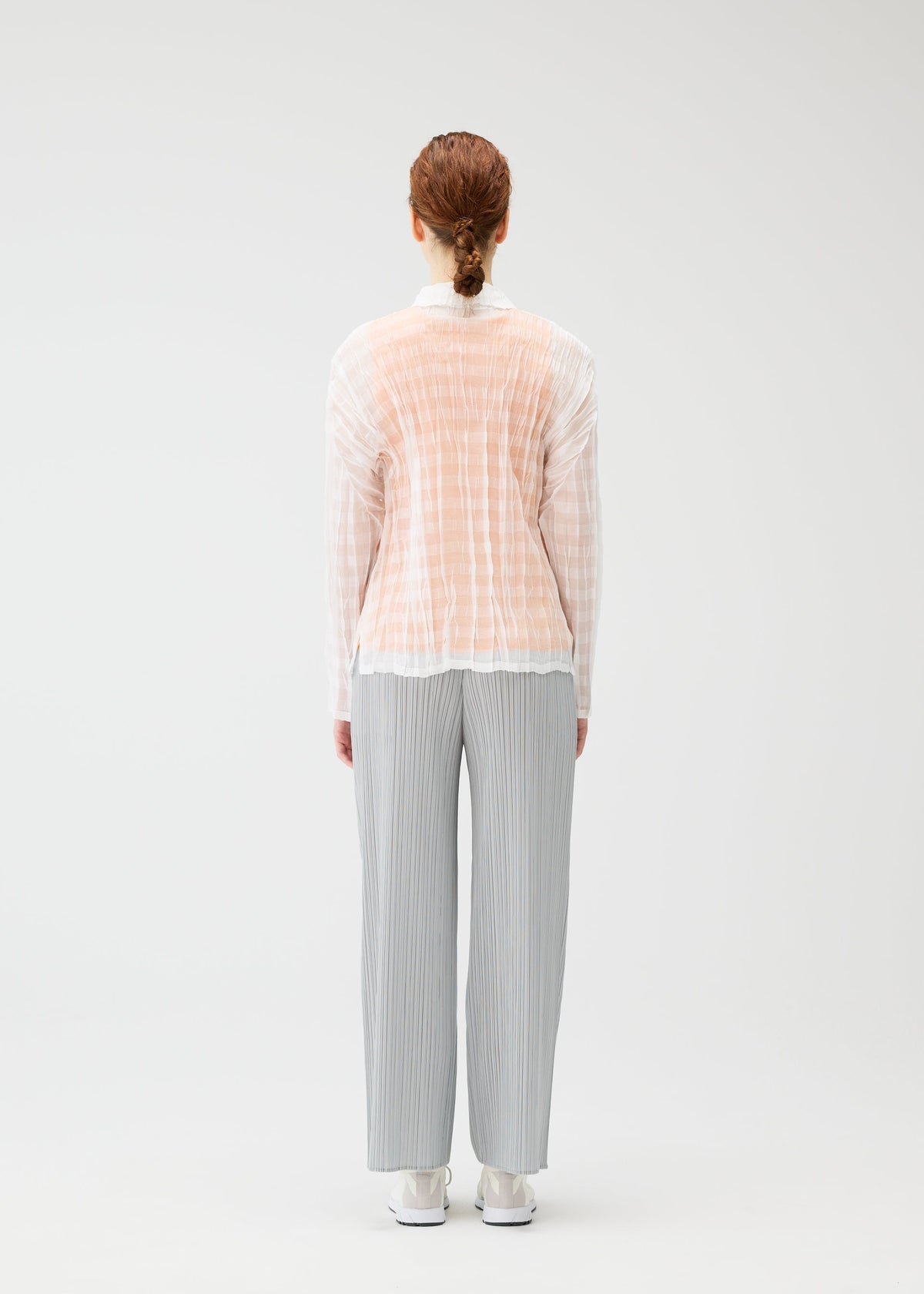 A model wears the PLEATS PLEASE ISSEY MIYAKE TWISTED BORDER SHIRT shirt.