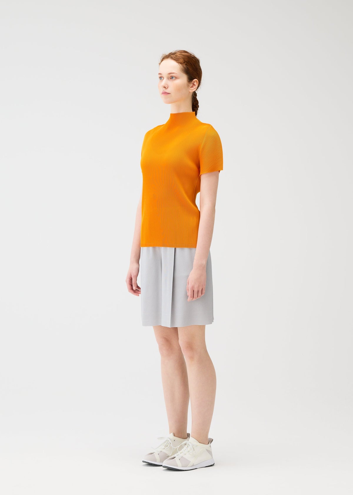 A model wears the PLEATS PLEASE ISSEY MIYAKE MIST APRIL shirt.