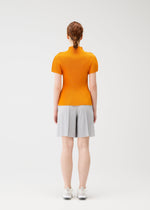 A model wears the PLEATS PLEASE ISSEY MIYAKE MIST APRIL shirt.