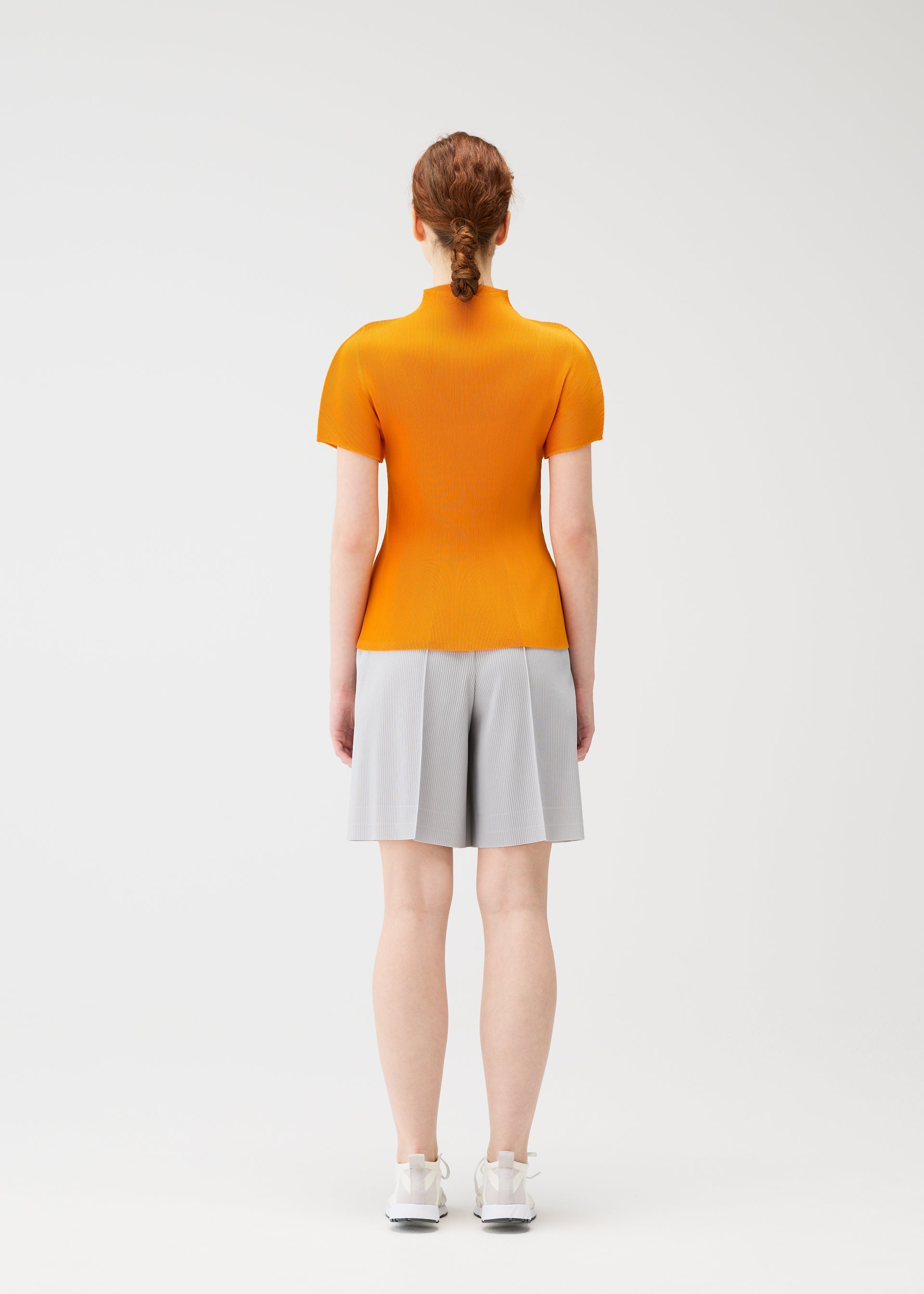 A model wears the PLEATS PLEASE ISSEY MIYAKE MIST APRIL shirt.