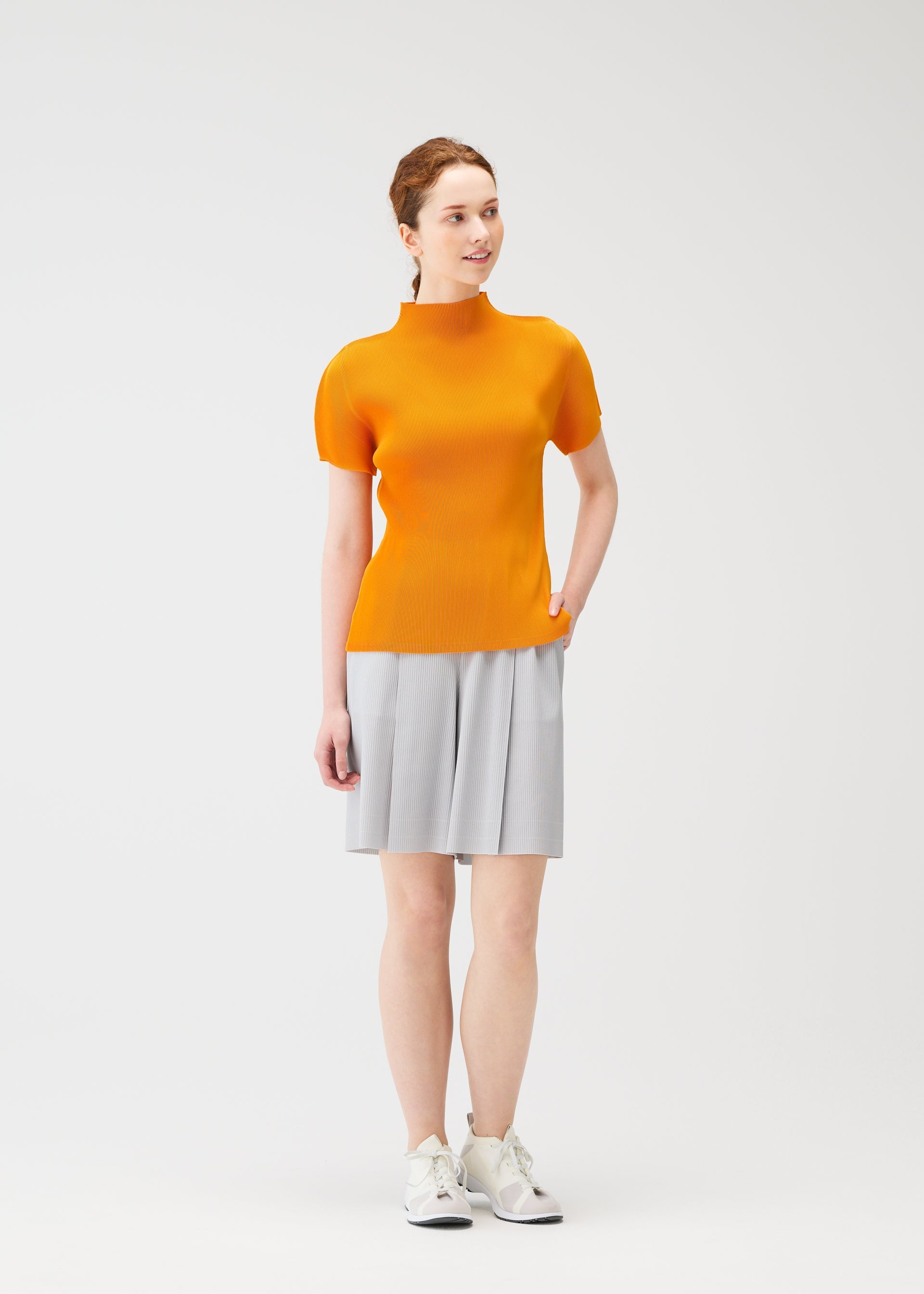 A model wears the PLEATS PLEASE ISSEY MIYAKE MIST APRIL shirt.