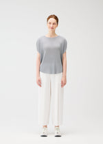 A model wears the PLEATS PLEASE ISSEY MIYAKE MIST APRIL shirt.