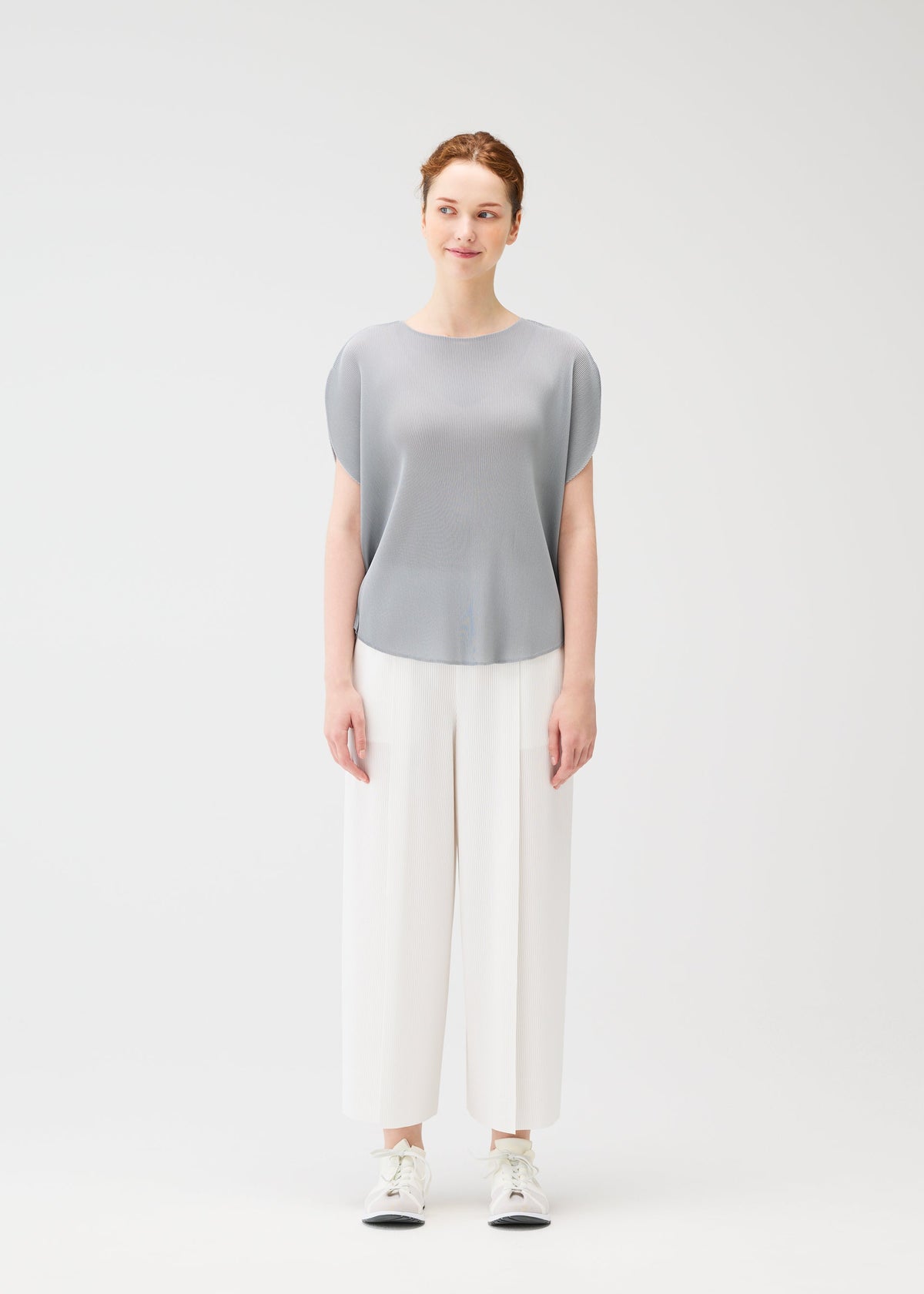 A model wears the PLEATS PLEASE ISSEY MIYAKE MIST APRIL shirt.