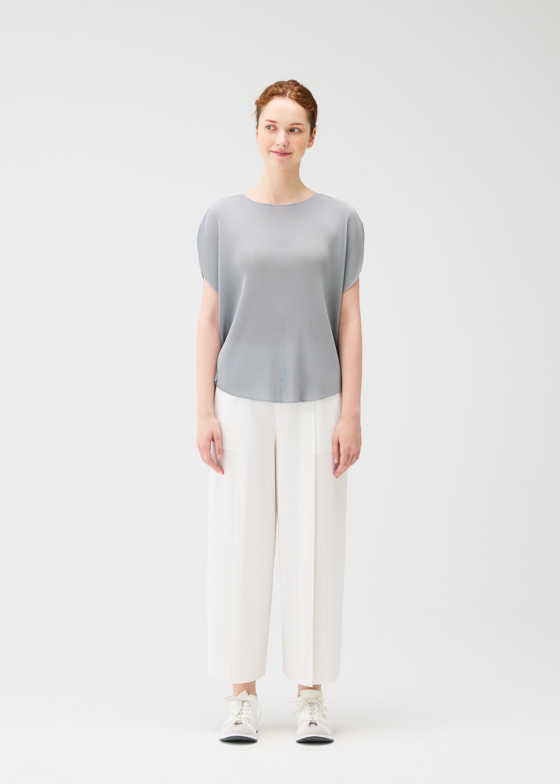 A model wears the PLEATS PLEASE ISSEY MIYAKE MIST APRIL shirt.