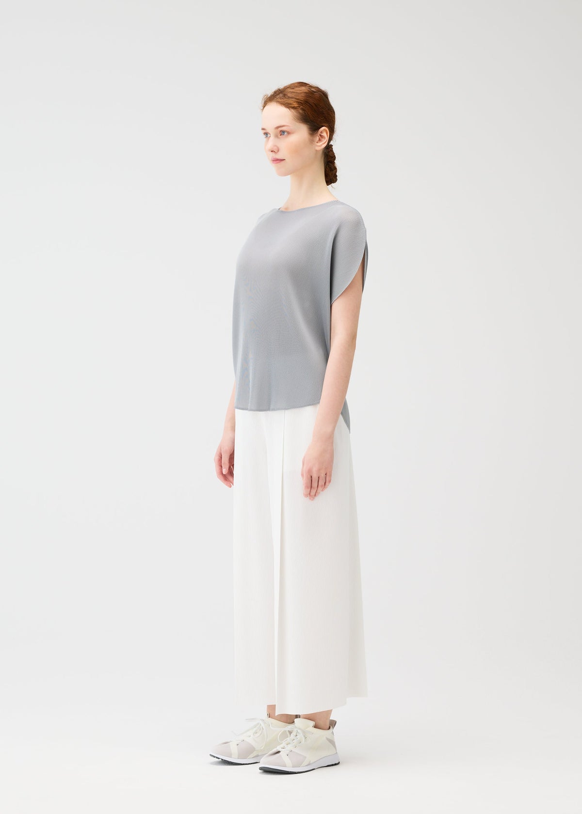 A model wears the PLEATS PLEASE ISSEY MIYAKE MIST APRIL shirt.