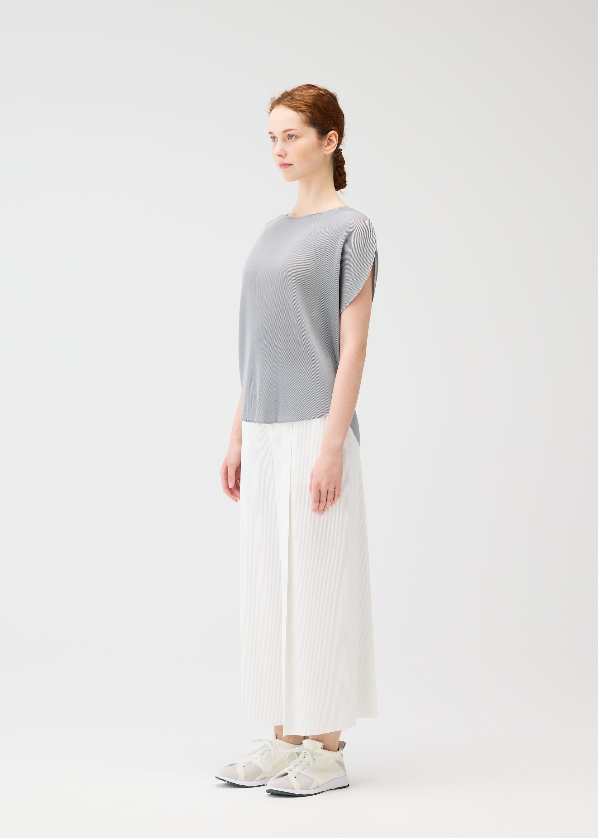 A model wears the PLEATS PLEASE ISSEY MIYAKE MIST APRIL shirt.