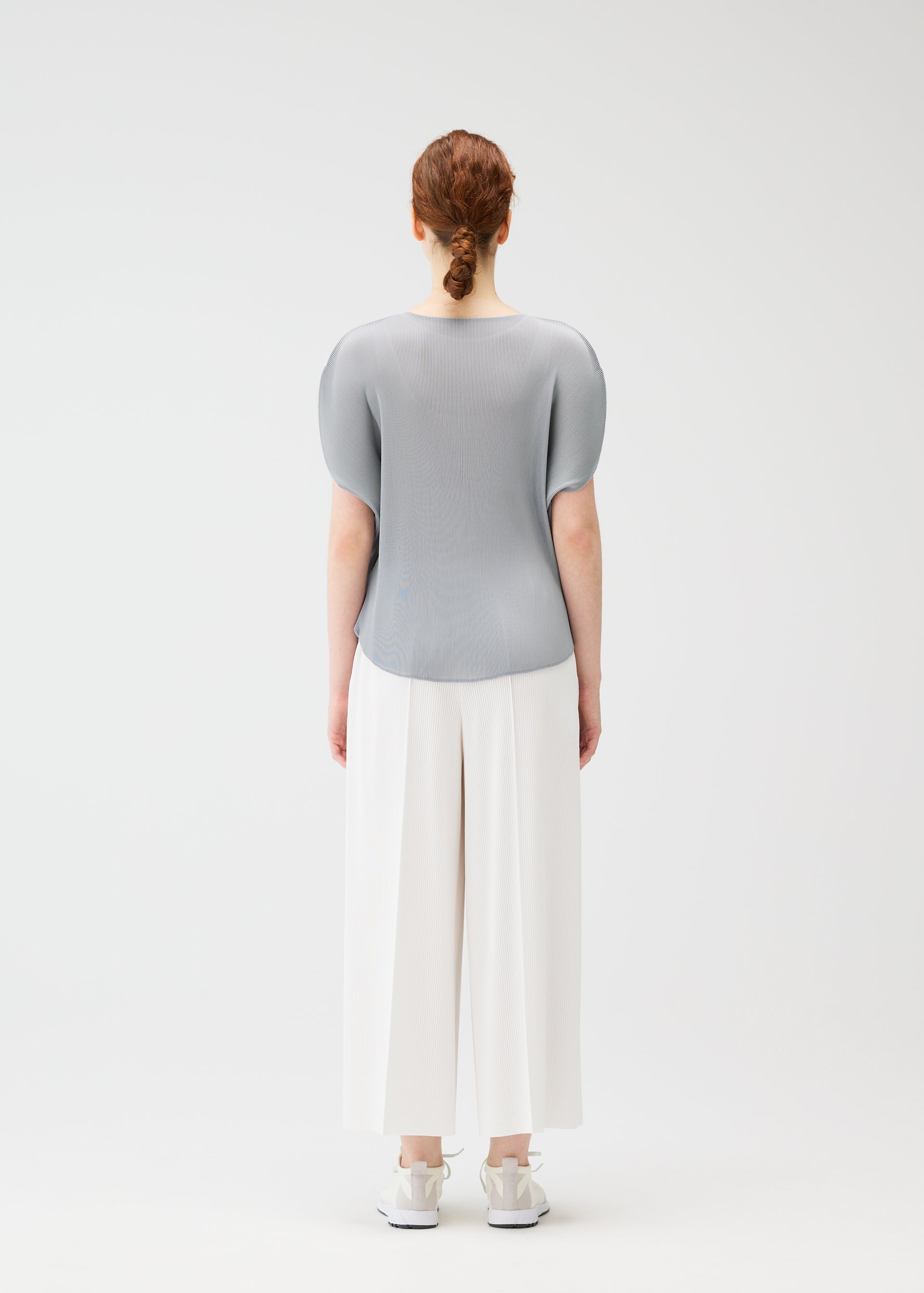 A model wears the PLEATS PLEASE ISSEY MIYAKE MIST APRIL shirt.