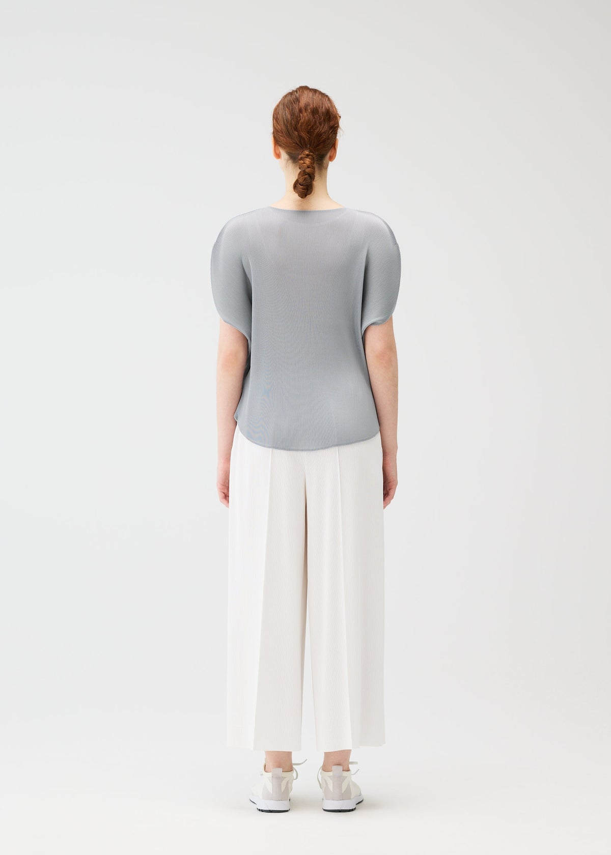 A model wears the PLEATS PLEASE ISSEY MIYAKE MIST APRIL shirt.