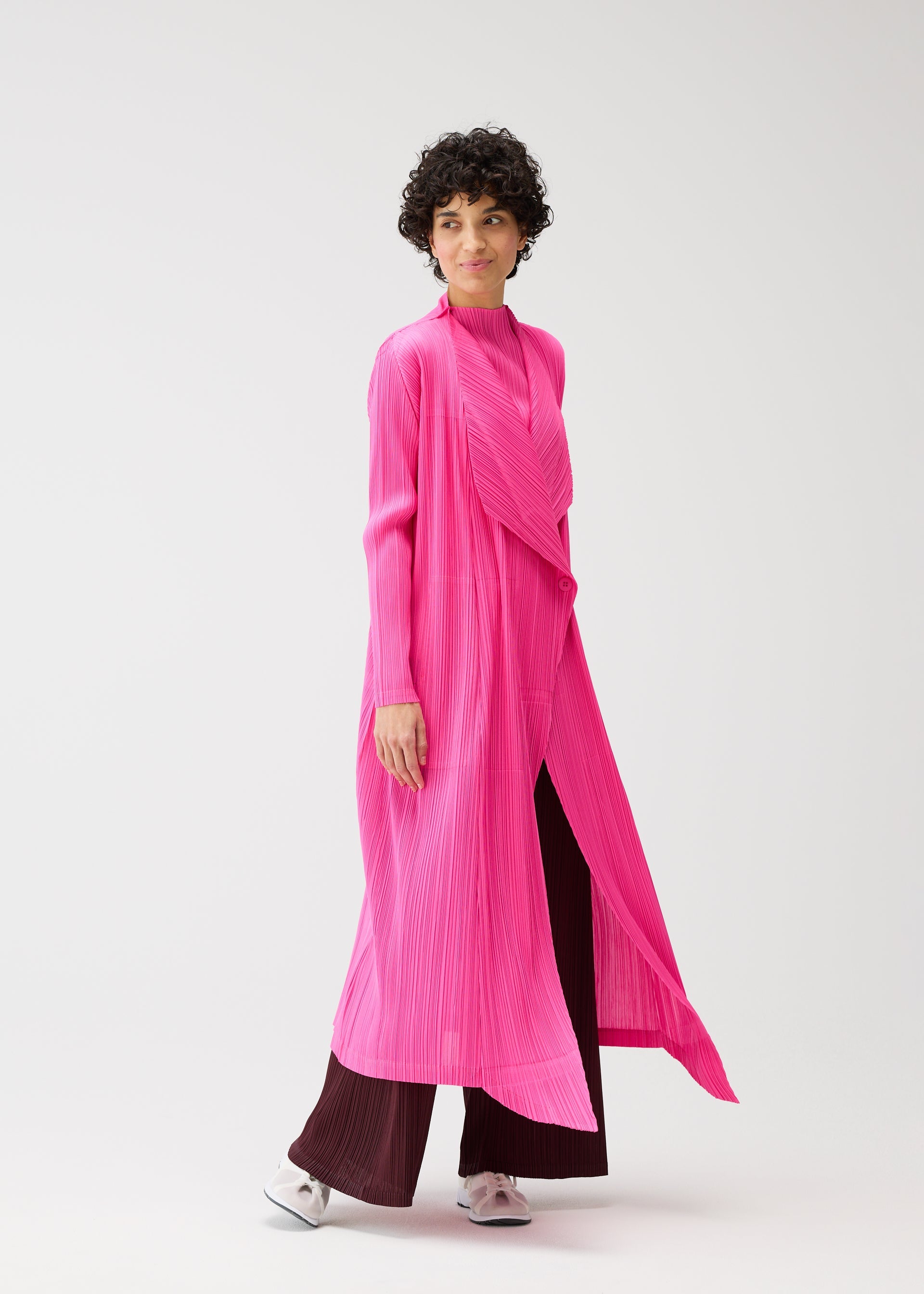 A model wears the PLEATS PLEASE ISSEY MIYAKE MONTHLY COLORS JANUARY clothing.