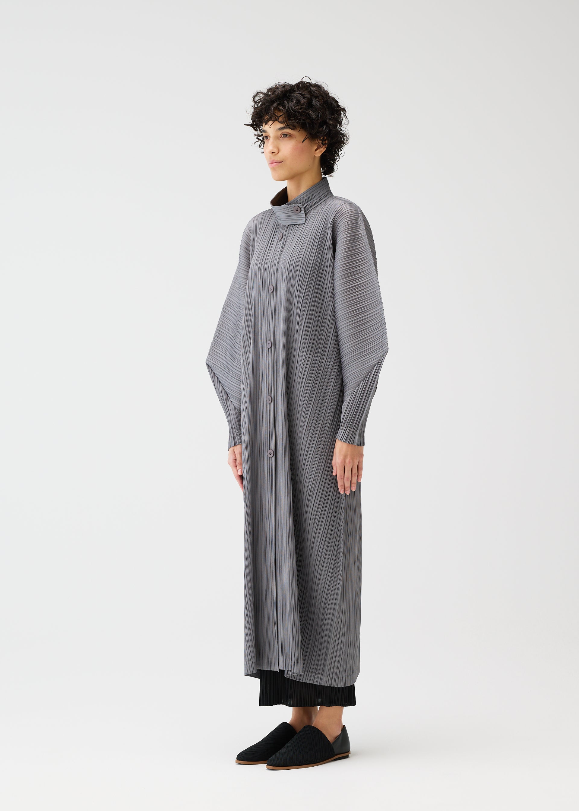 A model wears the PLEATS PLEASE ISSEY MIYAKE SKYLINE clothing.