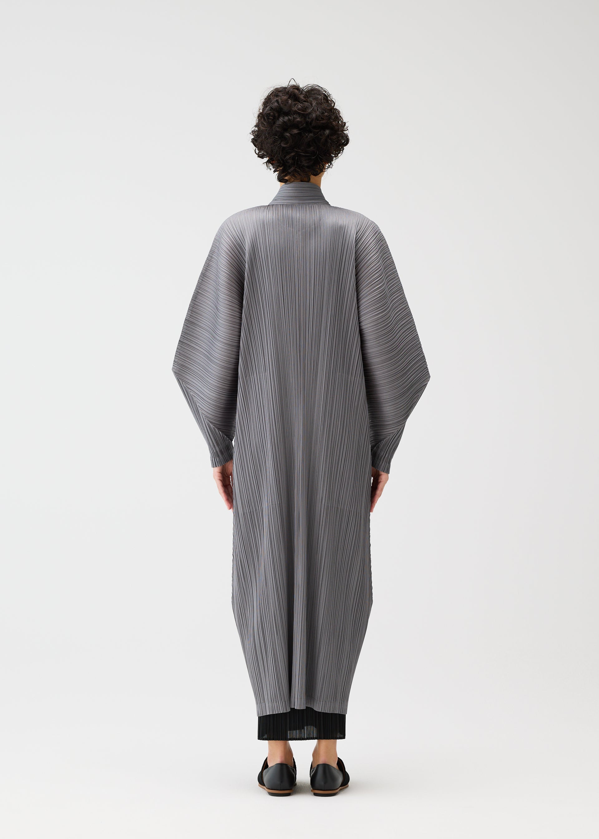 A model wears the PLEATS PLEASE ISSEY MIYAKE SKYLINE clothing.