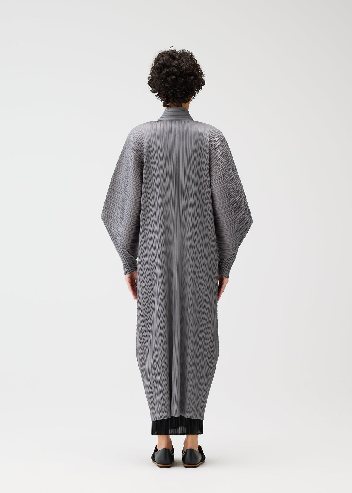A model wears the PLEATS PLEASE ISSEY MIYAKE SKYLINE clothing.