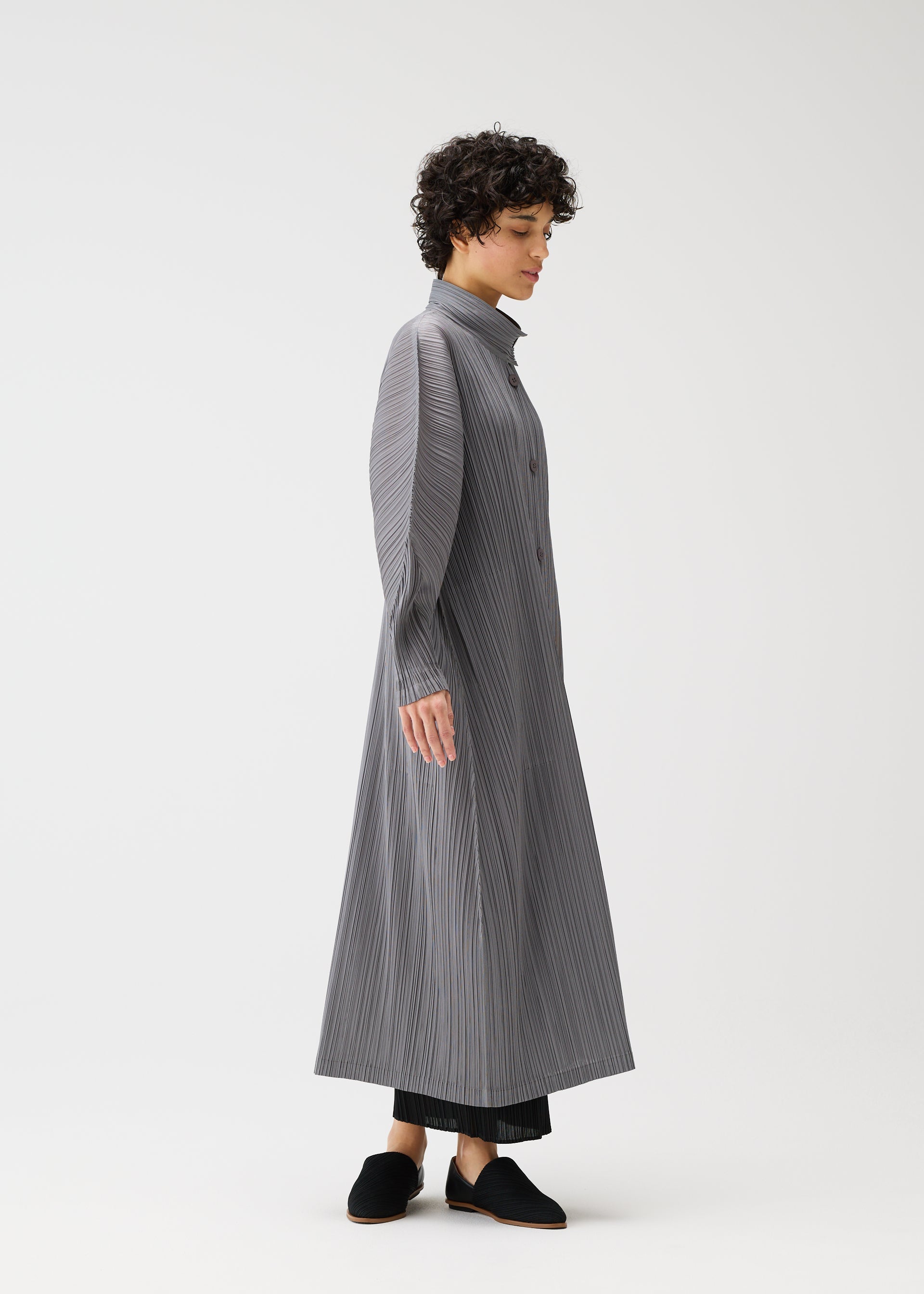 A model wears the PLEATS PLEASE ISSEY MIYAKE SKYLINE clothing.