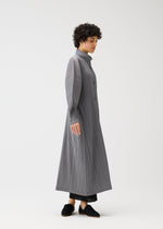 A model wears the PLEATS PLEASE ISSEY MIYAKE SKYLINE clothing.
