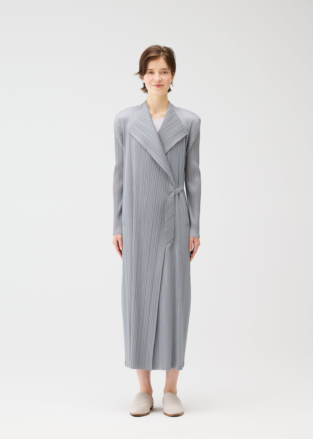 A model wears the PLEATS PLEASE ISSEY MIYAKE FACADE coat.