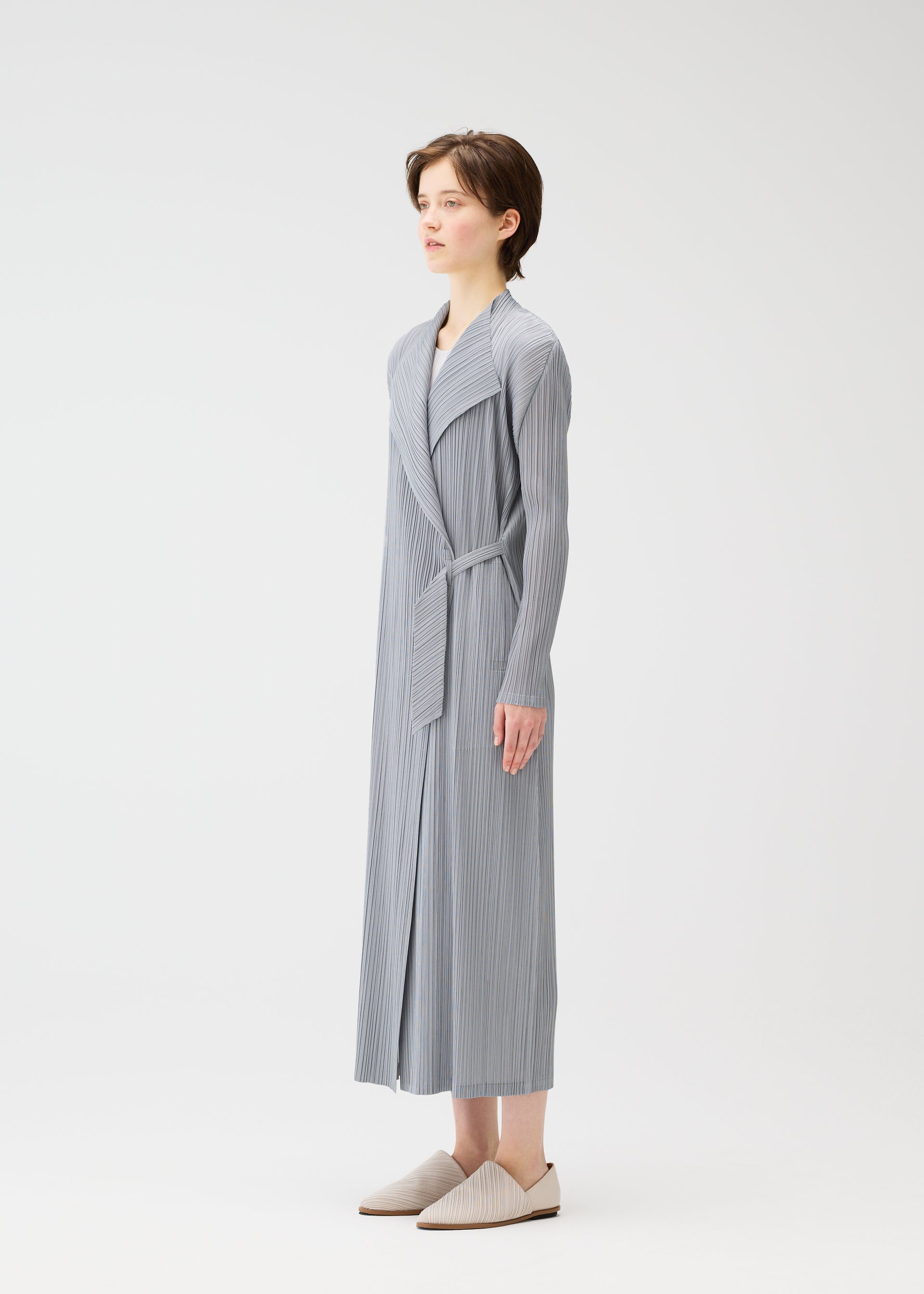 A model wears the PLEATS PLEASE ISSEY MIYAKE FACADE coat.