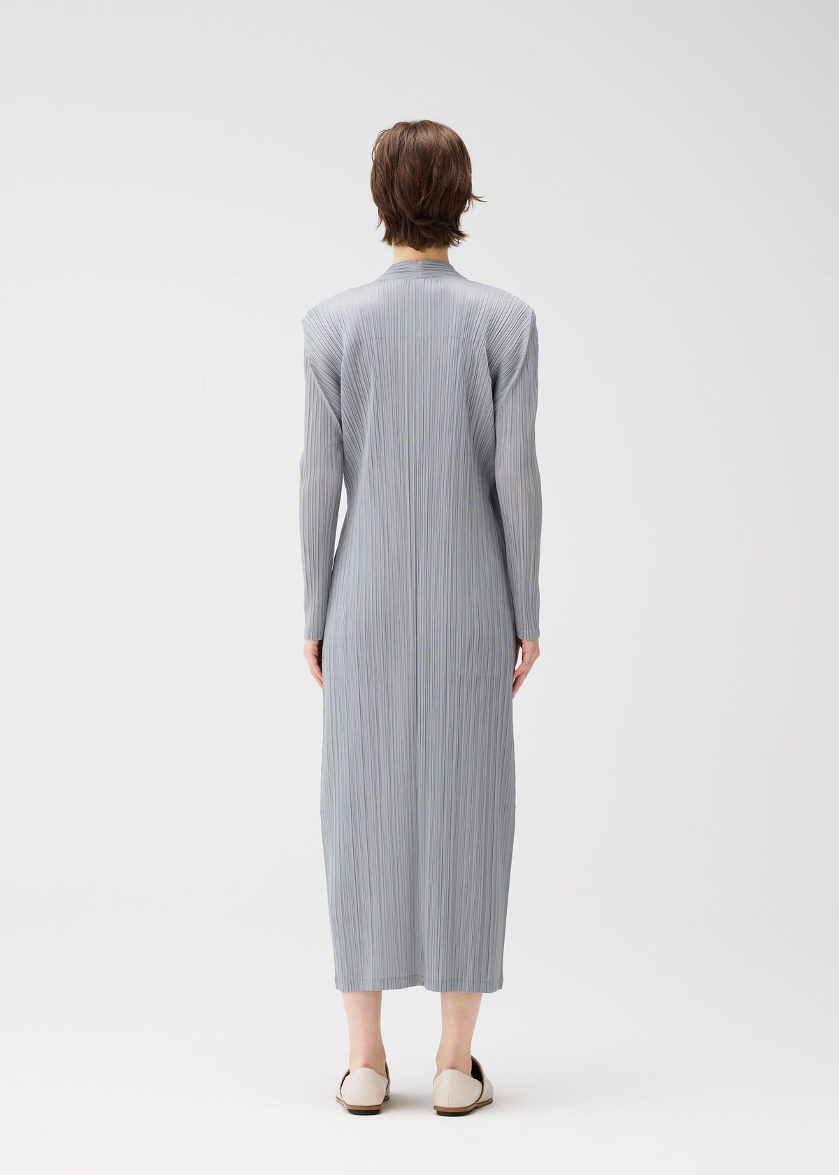 A model wears the PLEATS PLEASE ISSEY MIYAKE FACADE coat.