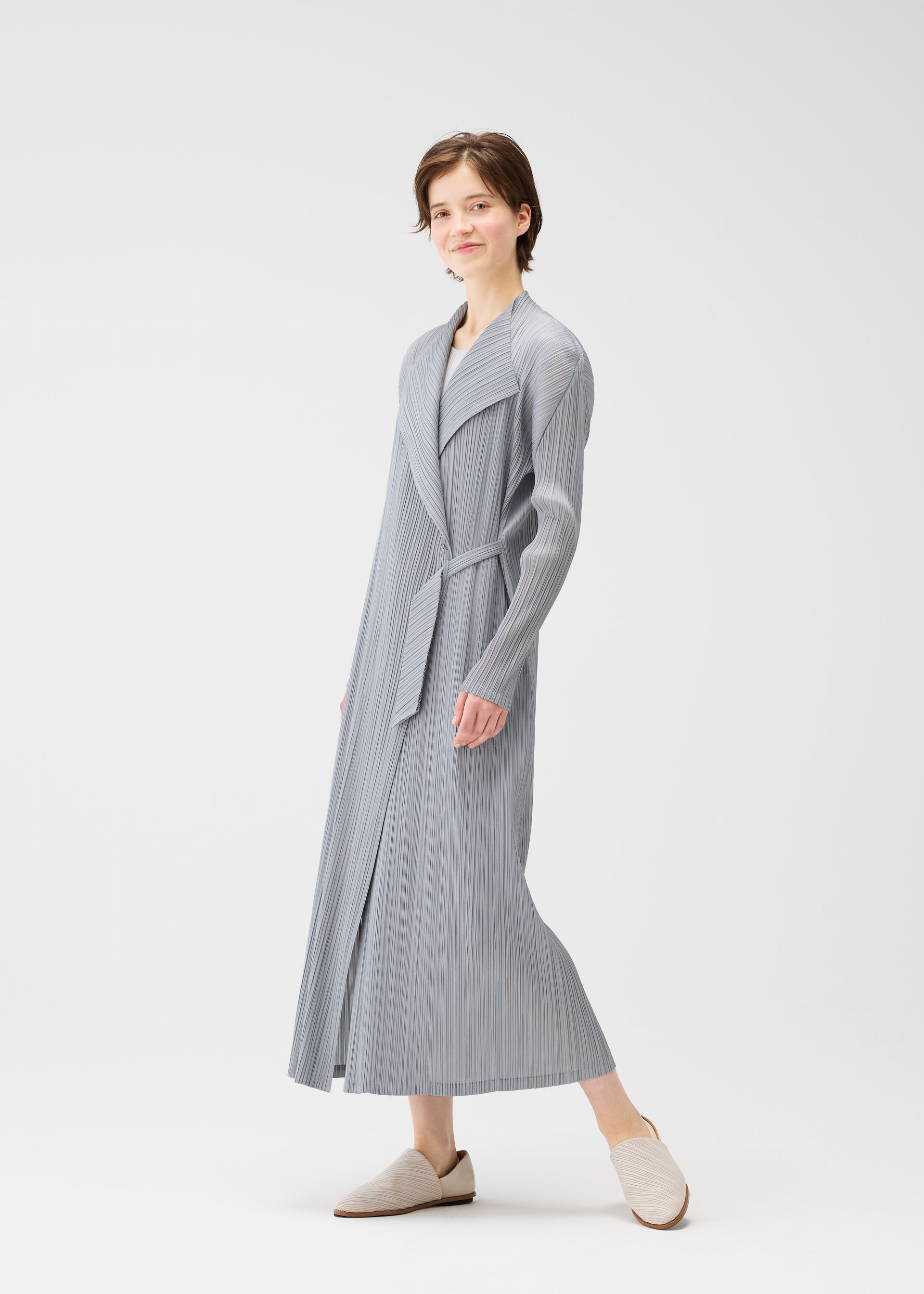A model wears the PLEATS PLEASE ISSEY MIYAKE FACADE coat.