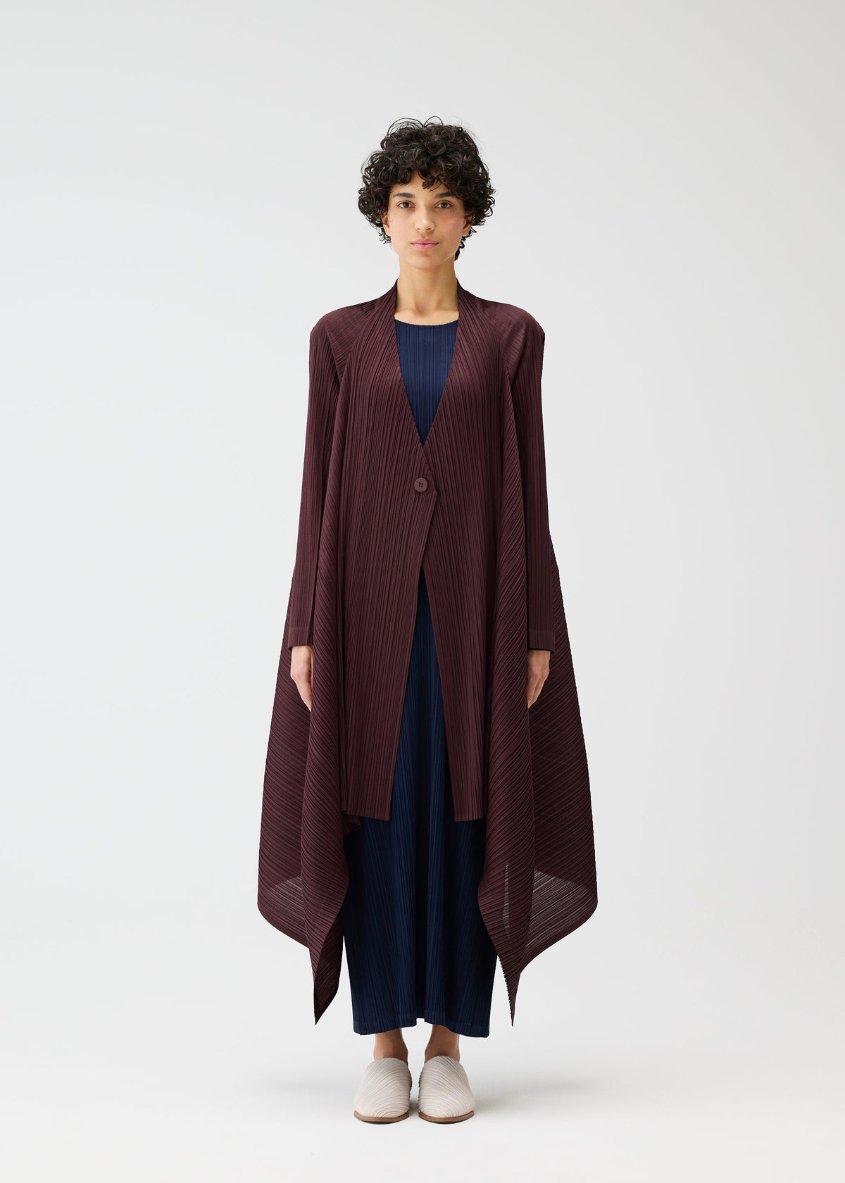 A model wears the PLEATS PLEASE ISSEY MIYAKE CITY FRAME coat.