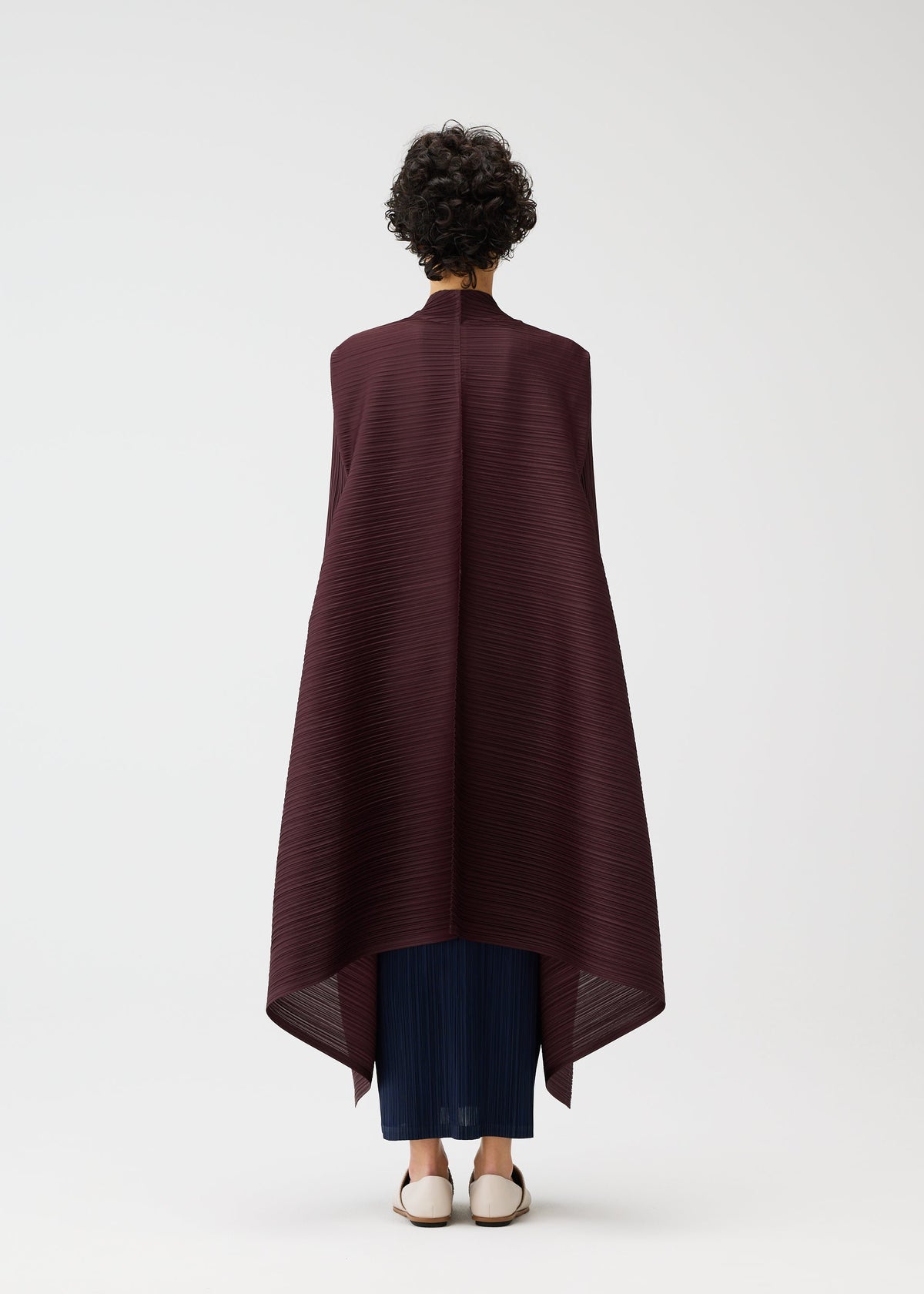 A model wears the PLEATS PLEASE ISSEY MIYAKE CITY FRAME coat.