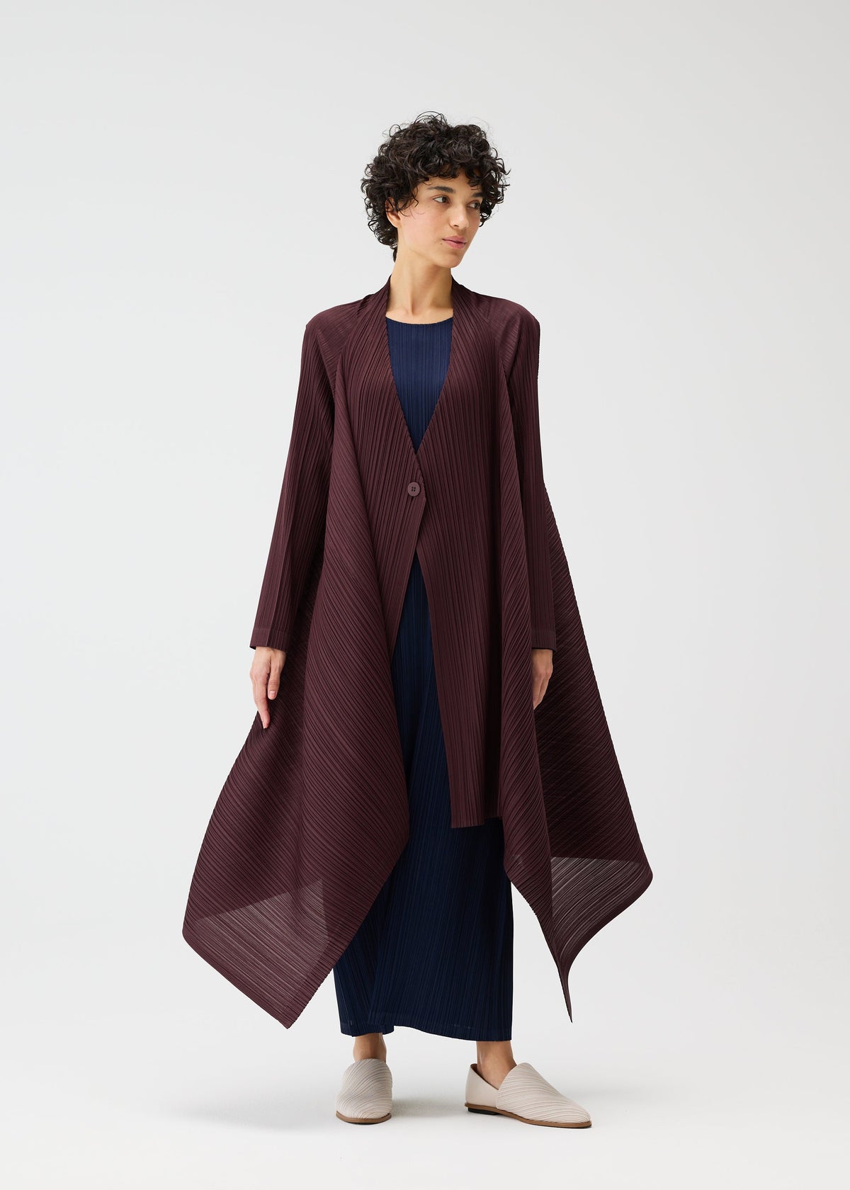 A model wears the PLEATS PLEASE ISSEY MIYAKE CITY FRAME coat.