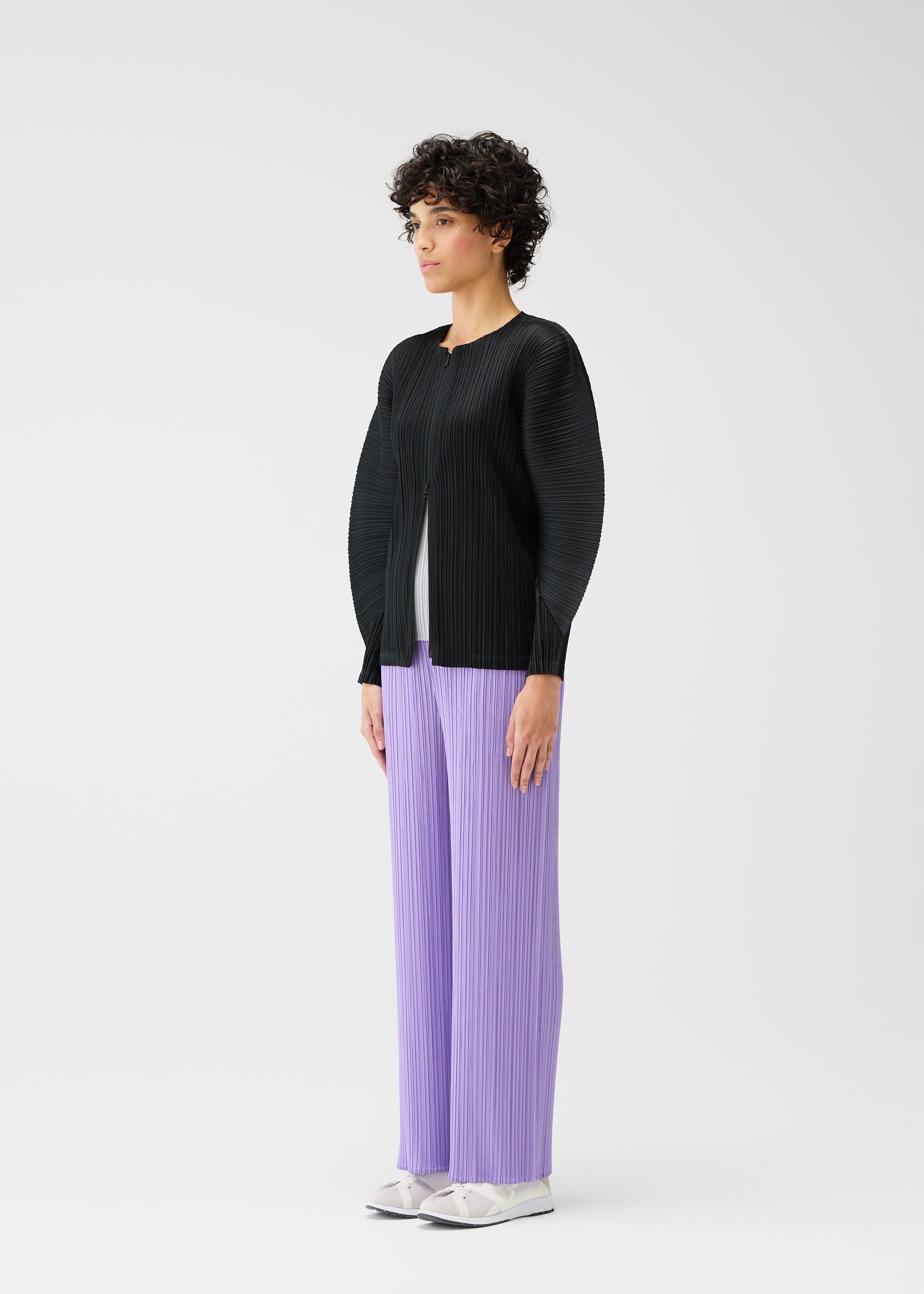A model wears the PLEATS PLEASE ISSEY MIYAKE MONTHLY COLORS APRIL jacket.