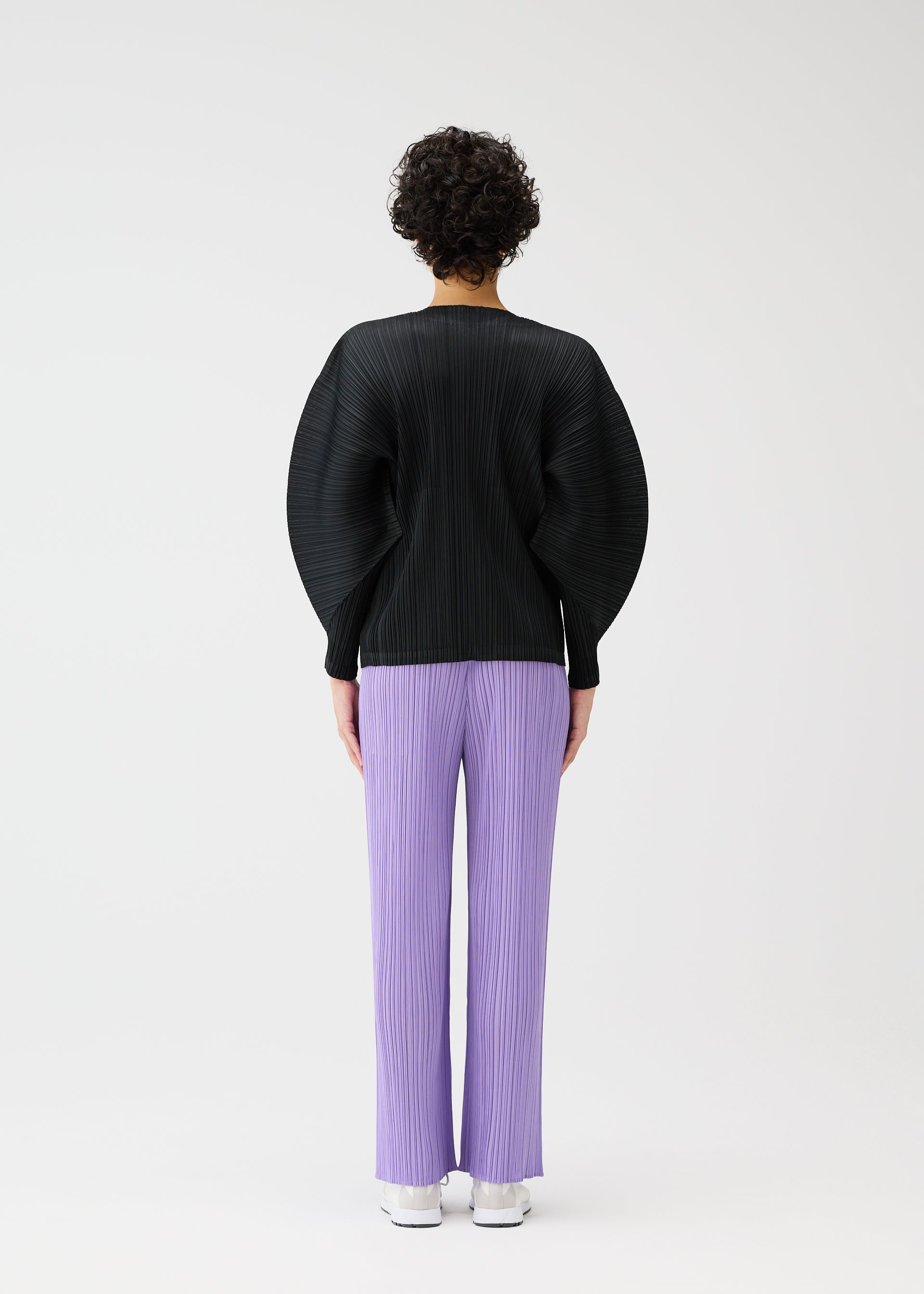 A model wears the PLEATS PLEASE ISSEY MIYAKE MONTHLY COLORS APRIL jacket.