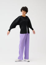 A model wears the PLEATS PLEASE ISSEY MIYAKE MONTHLY COLORS APRIL jacket.