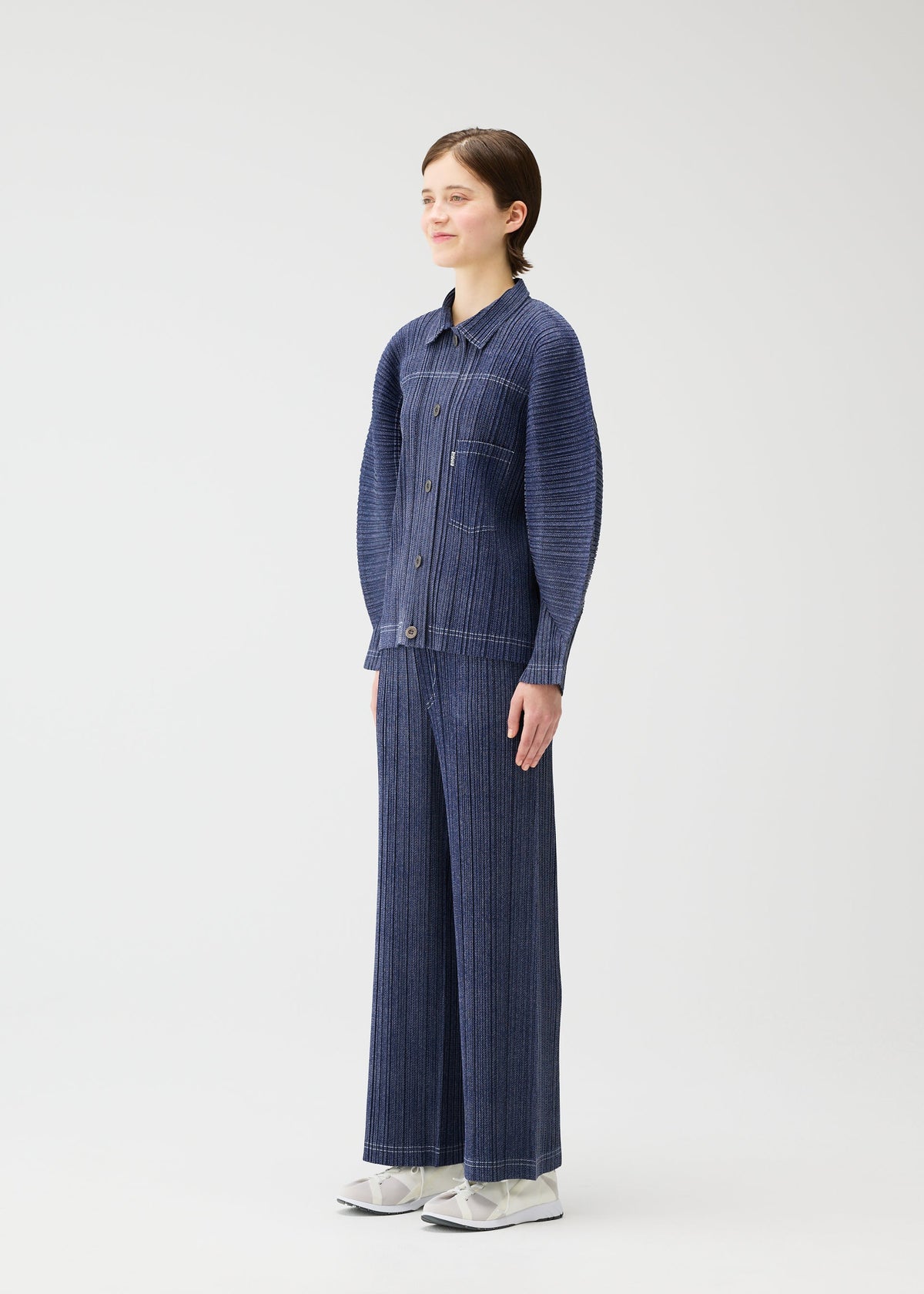 A model wears the PLEATS PLEASE ISSEY MIYAKE COTTON DENIM jacket.