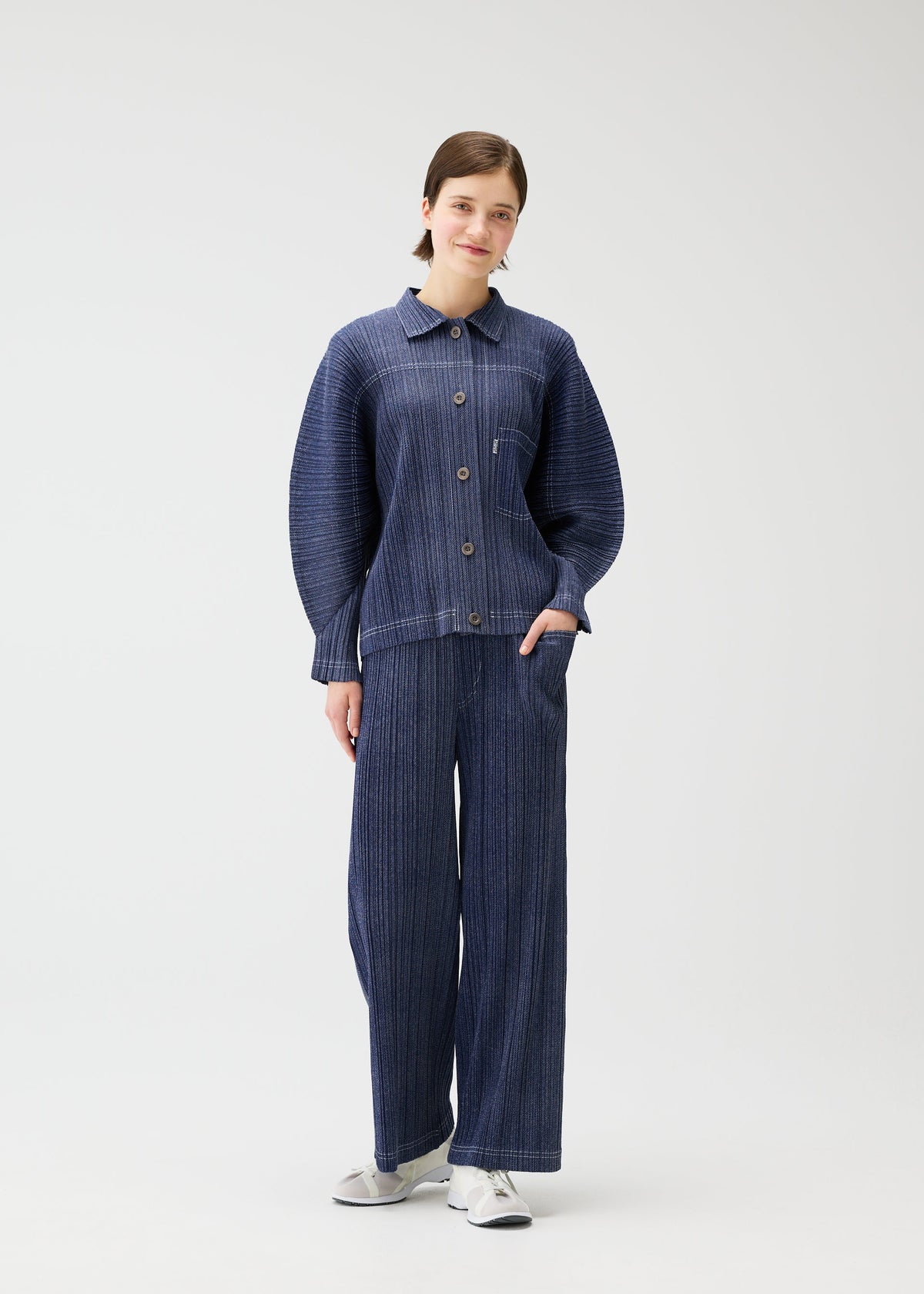 A model wears the PLEATS PLEASE ISSEY MIYAKE COTTON DENIM jacket.