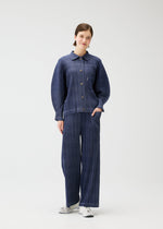 A model wears the PLEATS PLEASE ISSEY MIYAKE COTTON DENIM jacket.