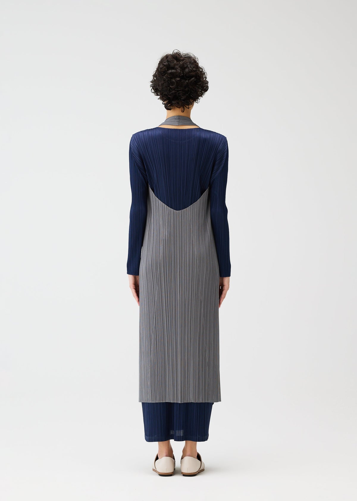 A model wears the PLEATS PLEASE ISSEY MIYAKE MONTHLY COLORS JANUARY clothing.