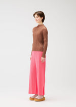 A model wears the PLEATS PLEASE ISSEY MIYAKE MONTHLY COLORS MARCH trousers.