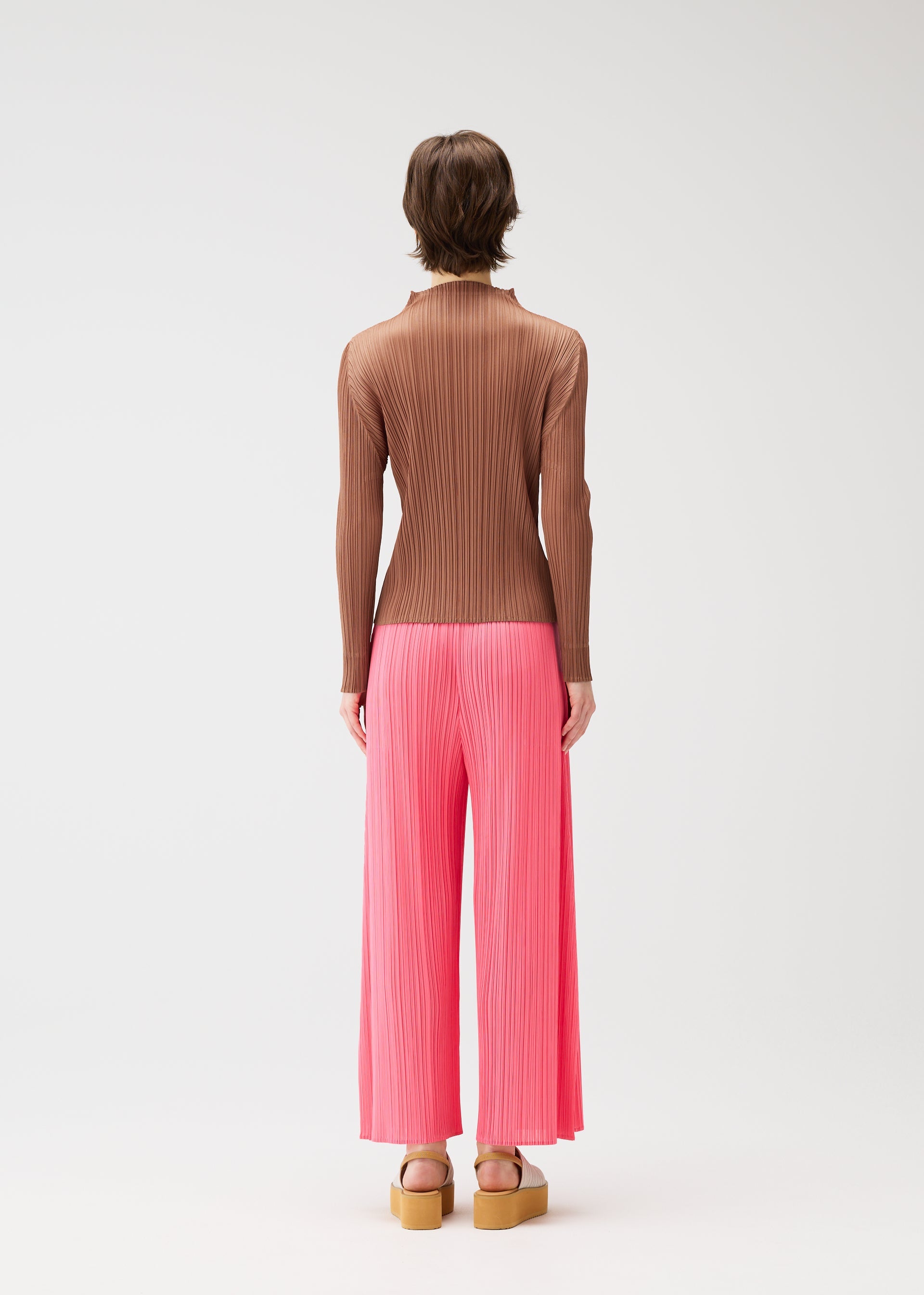 A model wears the PLEATS PLEASE ISSEY MIYAKE MONTHLY COLORS MARCH trousers.
