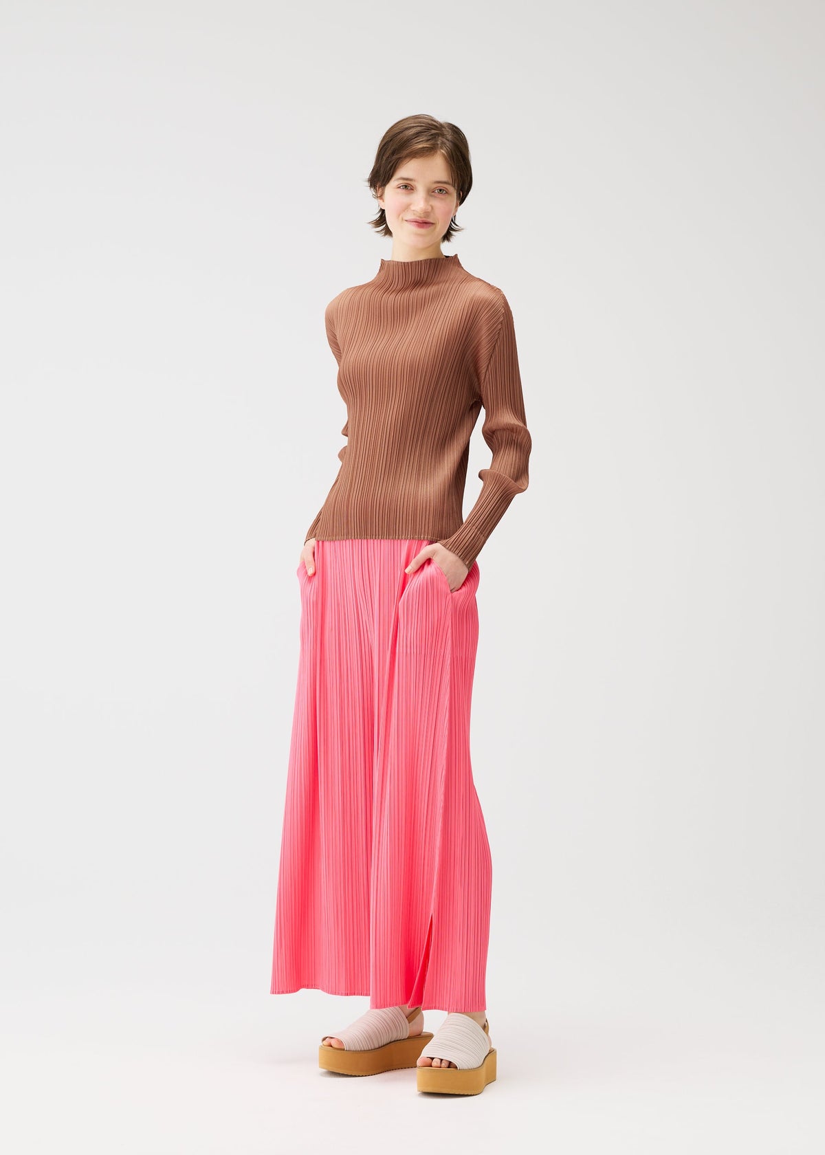 A model wears the PLEATS PLEASE ISSEY MIYAKE MONTHLY COLORS MARCH trousers.
