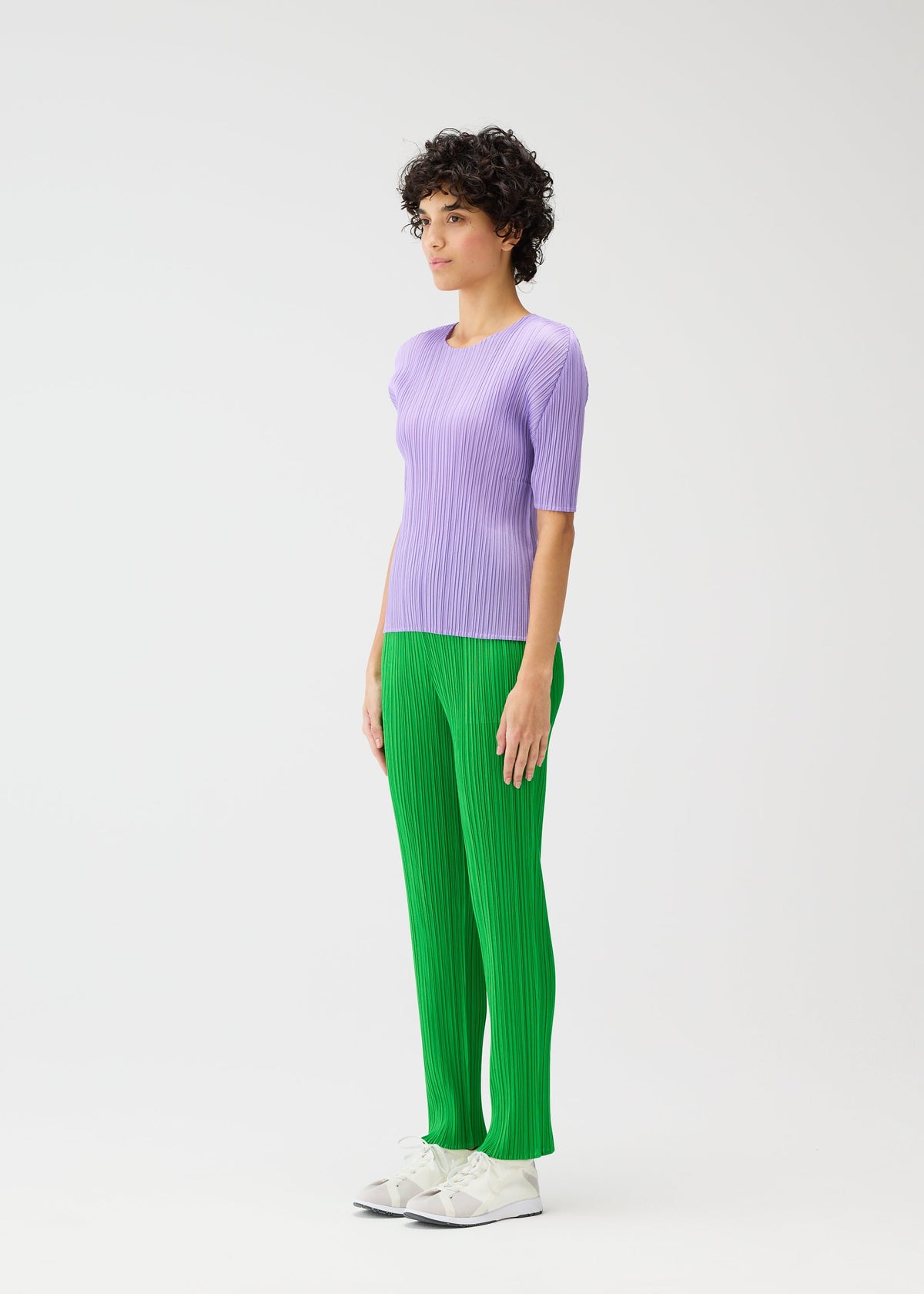 A model wears the PLEATS PLEASE ISSEY MIYAKE MONTHLY COLORS APRIL trousers.