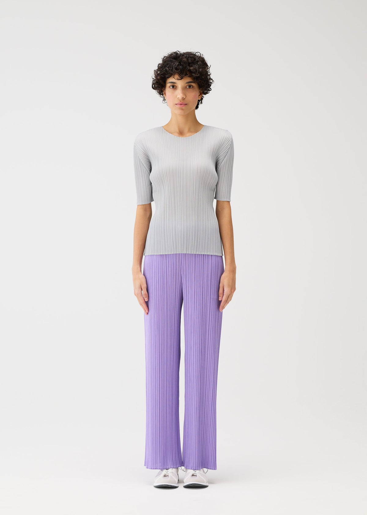 A model wears the PLEATS PLEASE ISSEY MIYAKE MONTHLY COLORS APRIL trousers.
