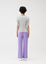 A model wears the PLEATS PLEASE ISSEY MIYAKE MONTHLY COLORS APRIL trousers.