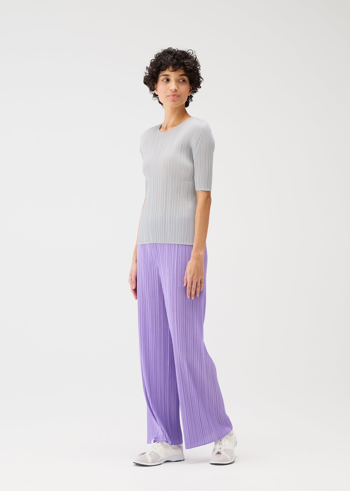A model wears the PLEATS PLEASE ISSEY MIYAKE MONTHLY COLORS APRIL trousers.
