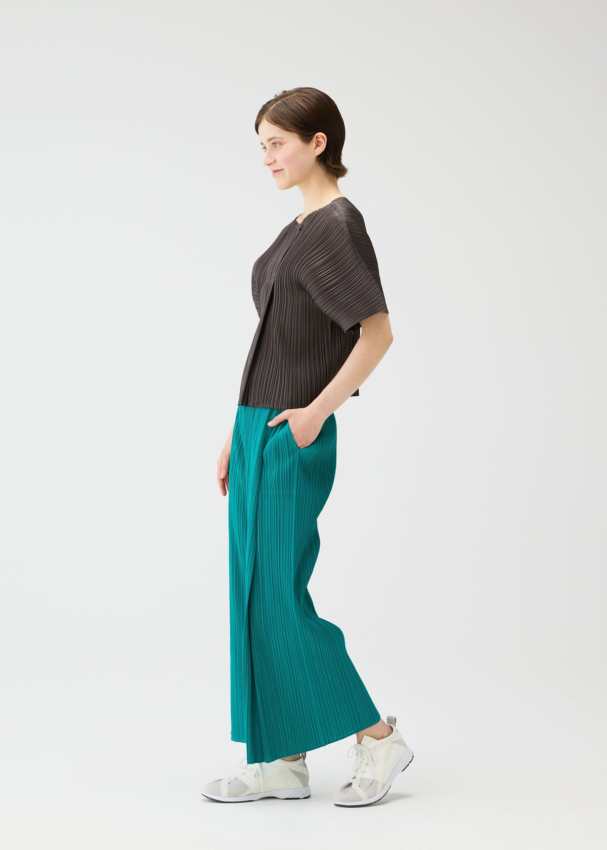 A model wears the PLEATS PLEASE ISSEY MIYAKE MONTHLY COLORS : JUNE monthly-colors-june-trousers-pink-beige.