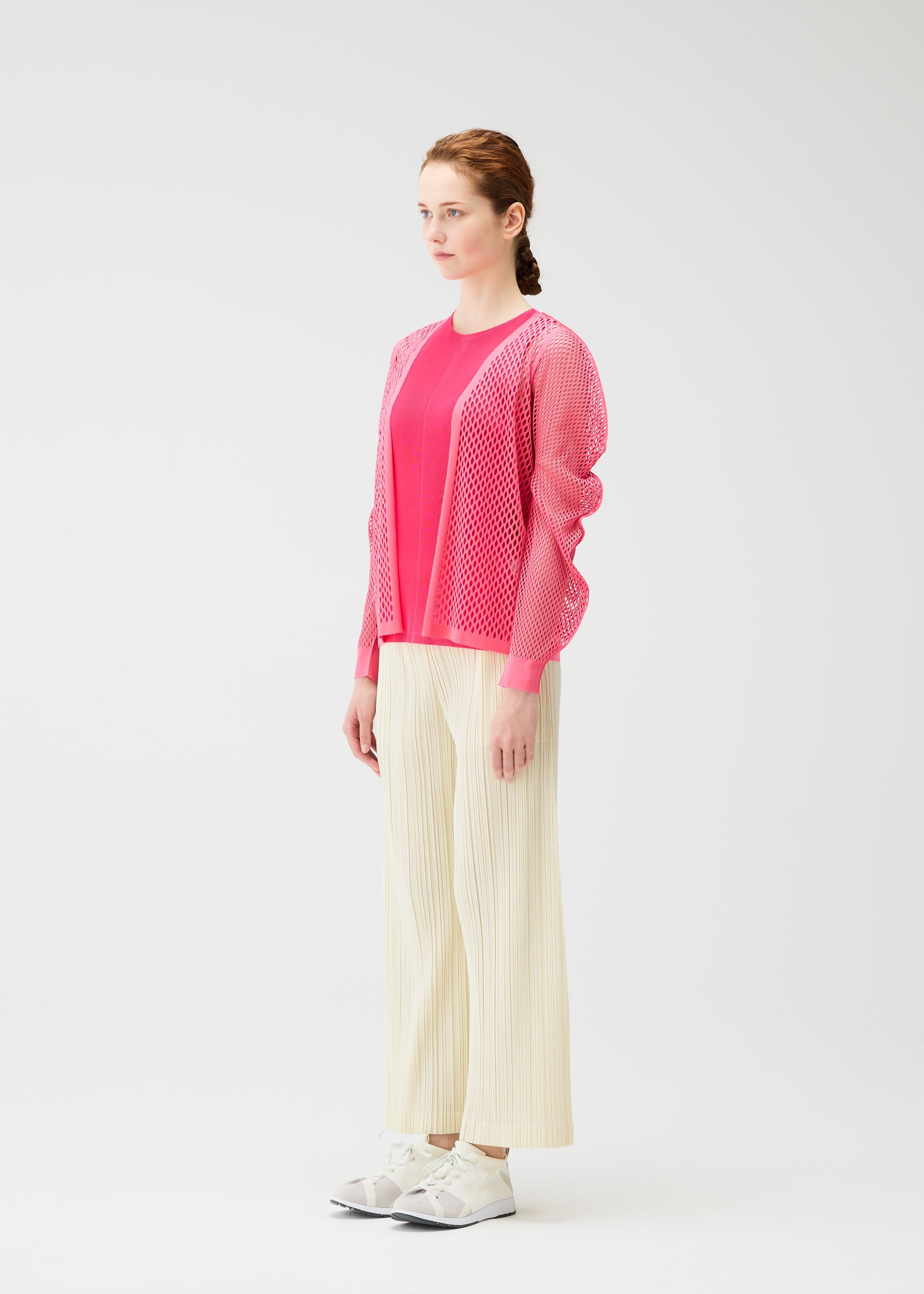 A model wears the PLEATS PLEASE ISSEY MIYAKE OPAQUE BOTTOMS opaque-bottoms-trousers-off-white.