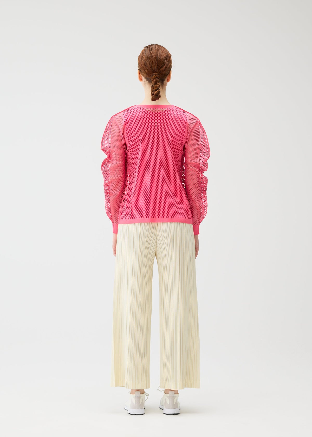 A model wears the PLEATS PLEASE ISSEY MIYAKE OPAQUE BOTTOMS opaque-bottoms-trousers-off-white.